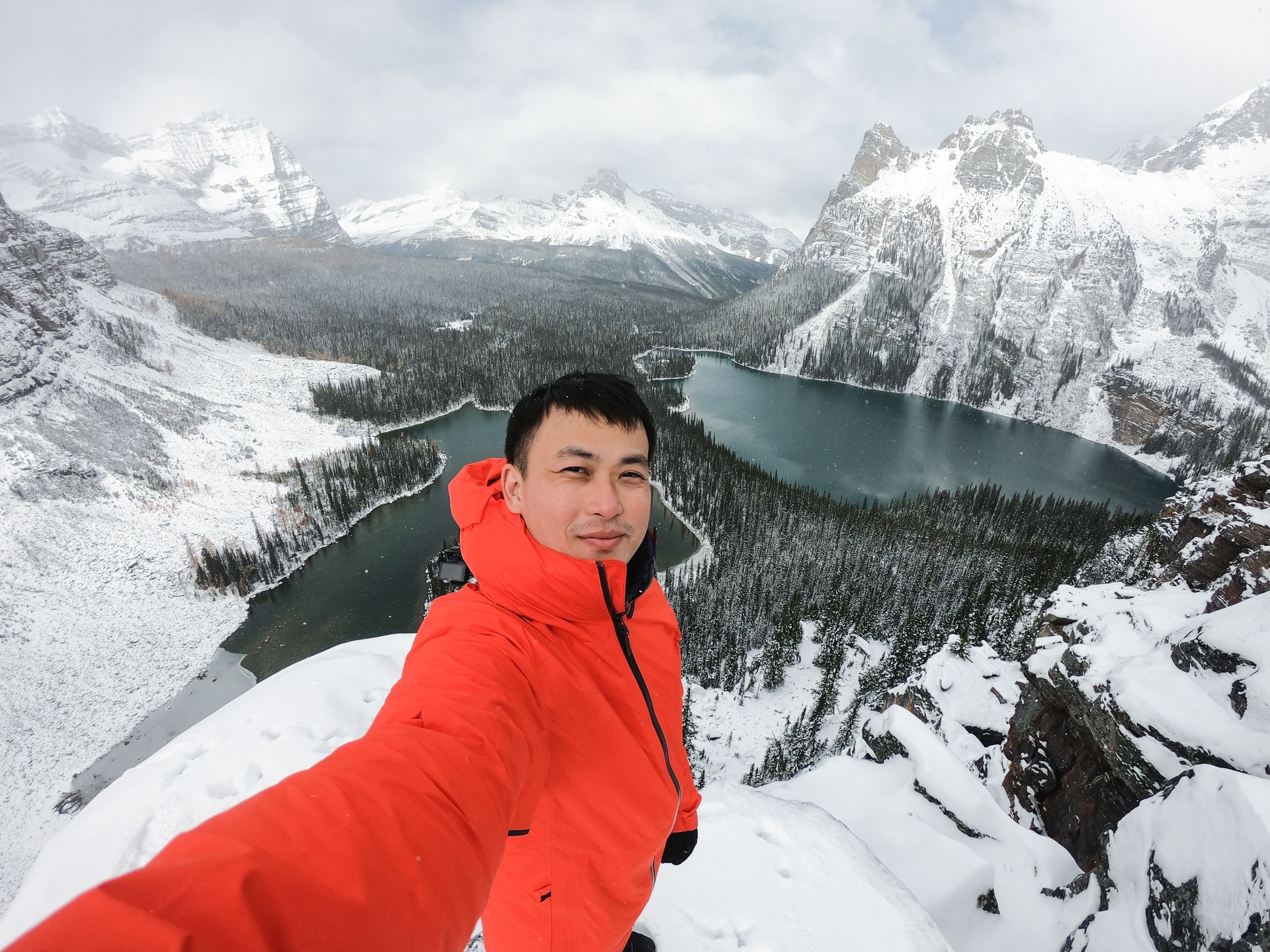 Asian hiker man selfie by camera during photograph on mountain peak in winter at Opabin Plateau